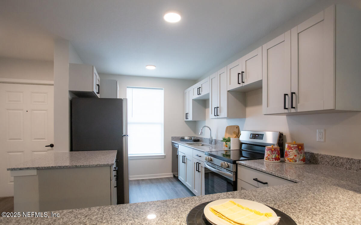 10109 Old St Augustine Road, Unit 1201 Jacksonville, FL 32257 - Photo 3 of 20 a kitchen with stainless steel appliances a refrigerator stove microwave and sink