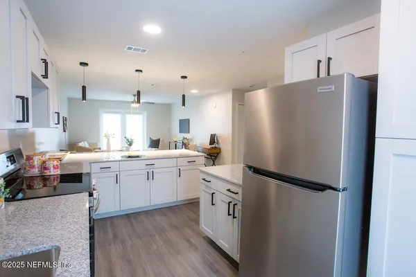 a kitchen with a refrigerator a sink and cabinets