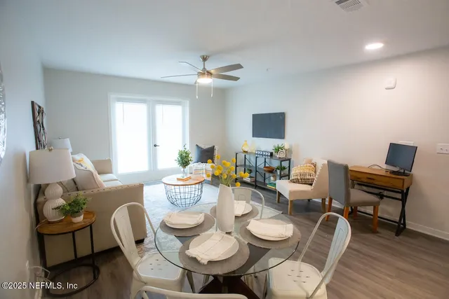 a view of a dining room with furniture a rug and wooden floor
