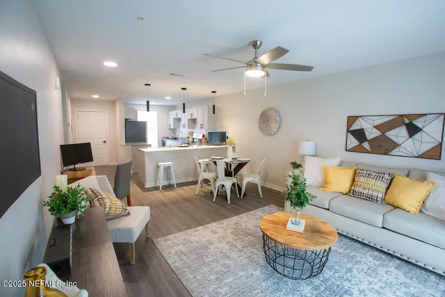 a living room with furniture kitchen view and a table