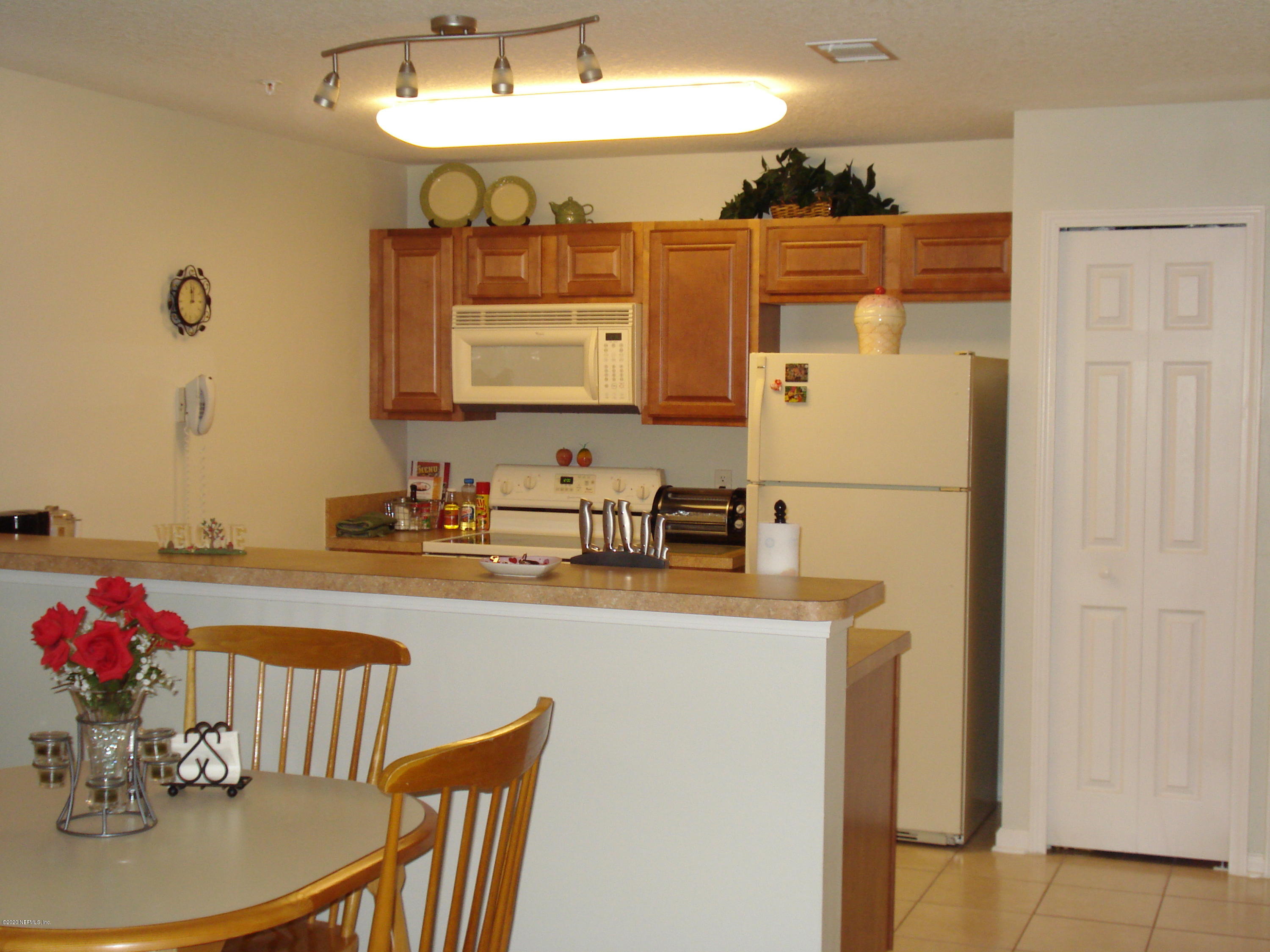 7920 Merrill Road, Unit 1413 Jacksonville, FL 32277 - Photo 3 of 4 a kitchen with a refrigerator and a sink
