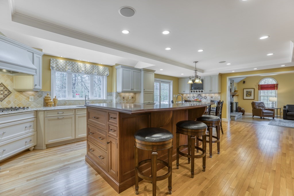 25 Baldpate Road Boxford, MA 01921 - Photo 15 of 42 a kitchen with stainless steel appliances kitchen island granite countertop a table chairs sink refrigerator and cabinets