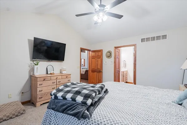 a bedroom with a large bed and a flat screen tv