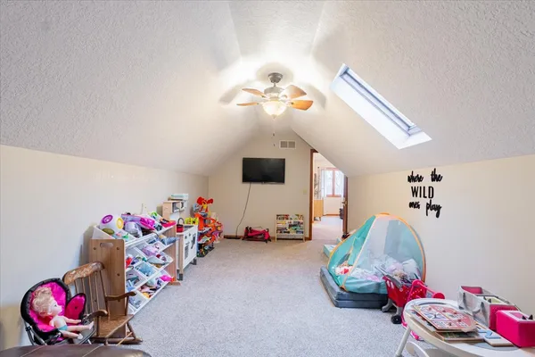 a bedroom with furniture and a chandelier fan