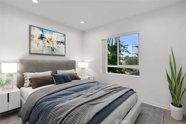 a bedroom with a large bed and a potted plant