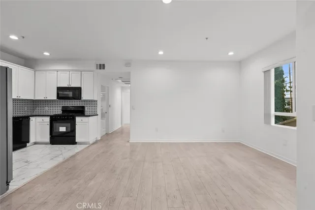 a view of kitchen with kitchen island granite countertop stainless steel appliances refrigerator sink and microwave