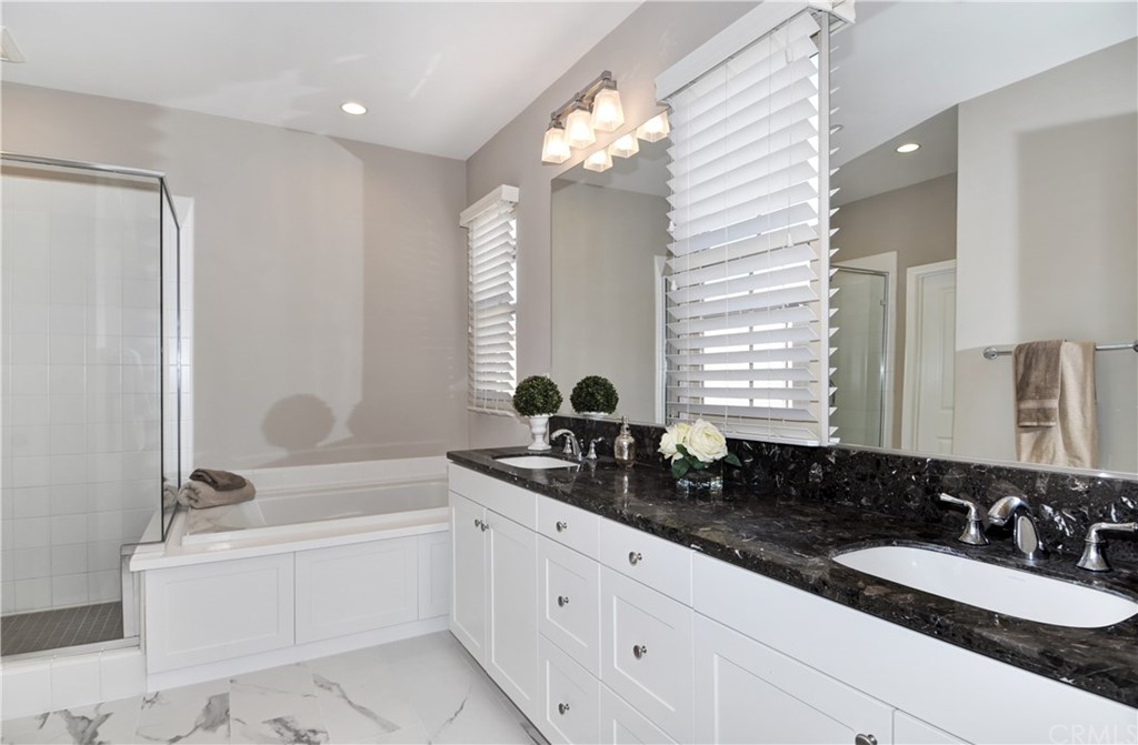 58 Ashdale Irvine, CA 92620 - Photo 11 of 18 a bathroom with a double vanity sink a mirror and a bathtub