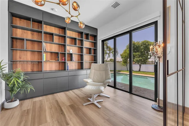 a view of a hallway with a large window and chandelier