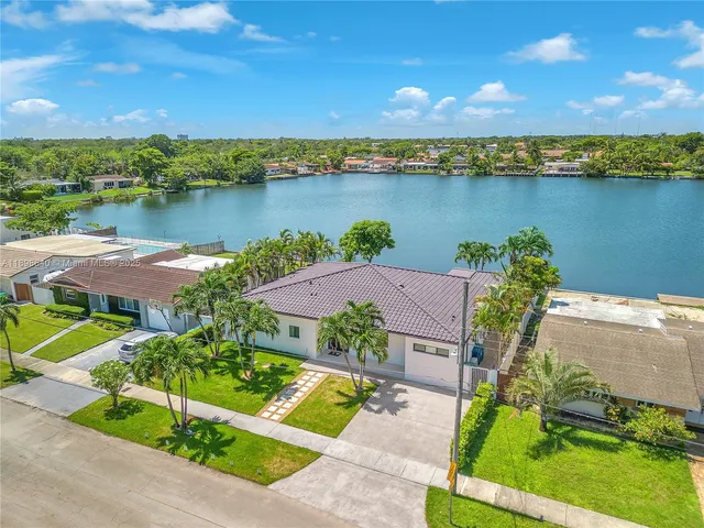 an aerial view of a house with a yard and lake view