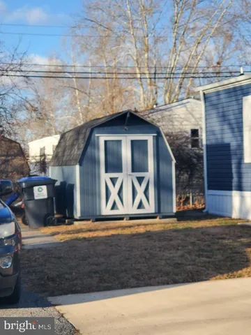 a front view of a house with large trees