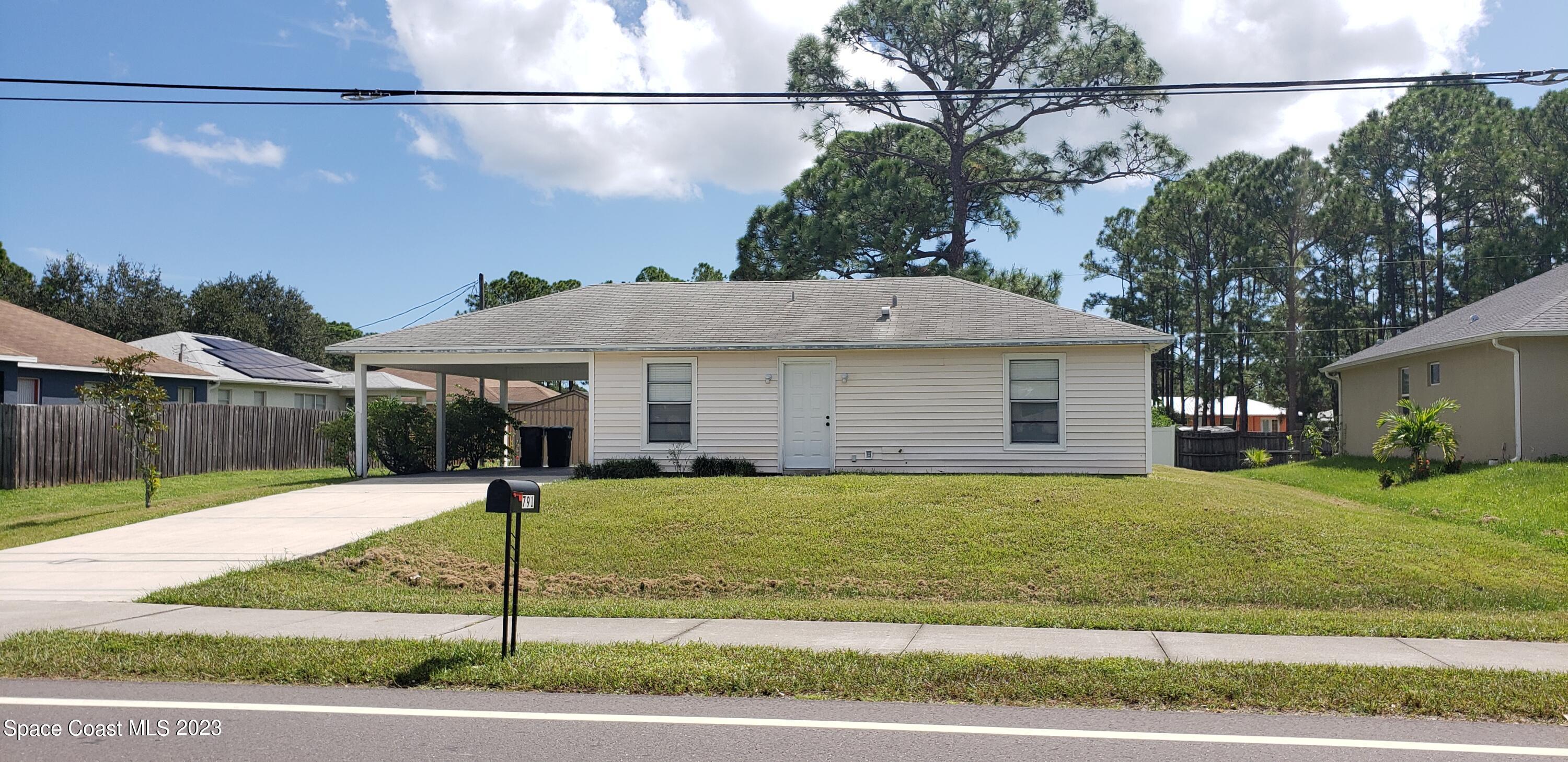 791 Degroodt Road Southwest Palm Bay, FL 32908 - Photo 4 of 47 a front view of a house with a yard and garage