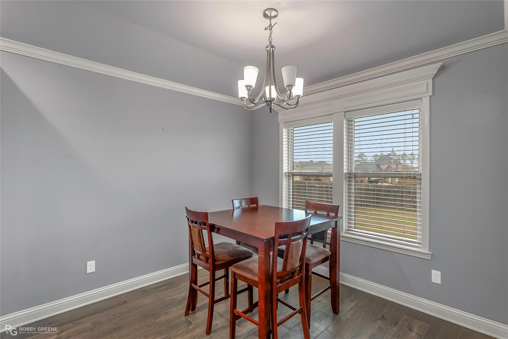 4917 Players Loop Blanchard, LA 71107 - Photo 15 of 31 a dining room with wooden floor a chandelier a wooden table and chairs