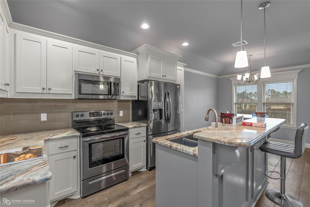 4917 Players Loop Blanchard, LA 71107 - Photo 20 of 31 a kitchen with kitchen island granite countertop a sink stainless steel appliances and white cabinets