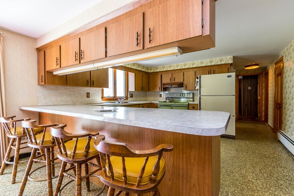 10 Dowd Avenue Wareham, MA 02571 - Photo 7 of 34 a kitchen with a table chairs refrigerator and cabinets