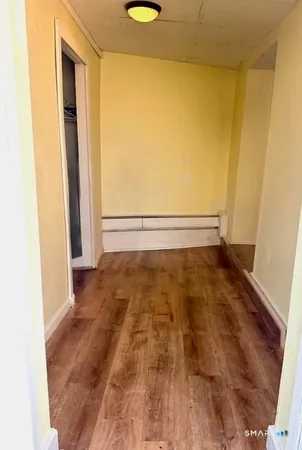 a view of a room with wooden floor and a window