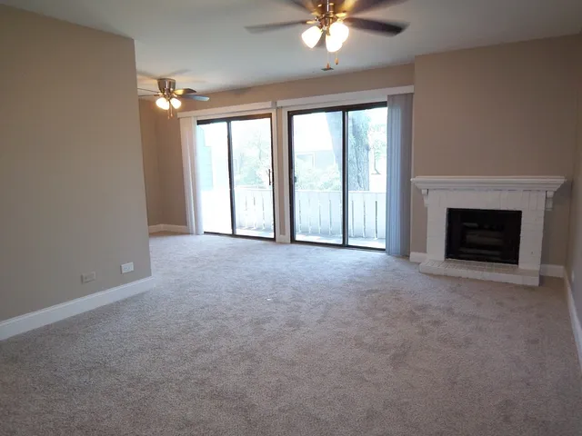 wooden floor fireplace and windows in an empty room