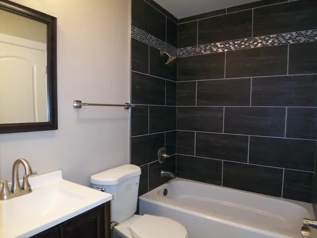 a bathroom with a bathtub a sink a toilet and a mirror