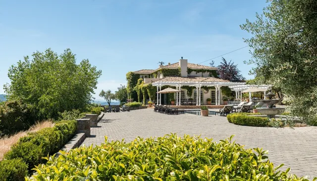 a view of a house with a big yard and potted plants