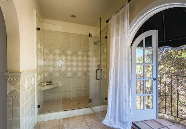 a bathroom with a glass shower door and a glass door