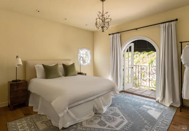 a spacious bedroom with a balcony a bed and a window