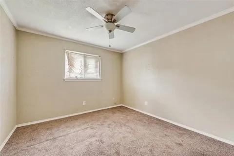 an empty room with a ceiling fan and window