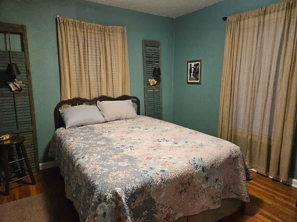 a large bed sitting in a bedroom next to a window