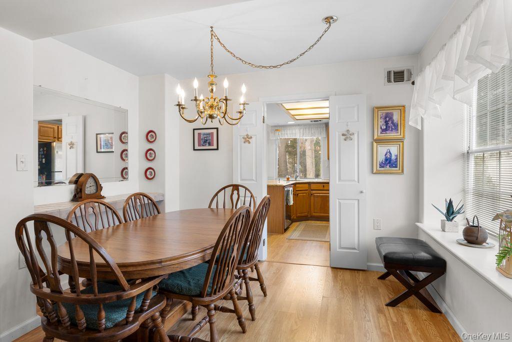 16 Huntington Court Ridge, NY 11961 - Photo 11 of 43 a view of a dining room with furniture a chandelier and wooden floor