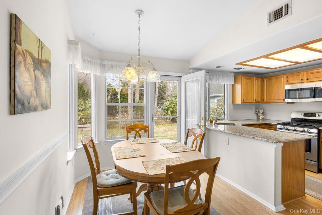 16 Huntington Court Ridge, NY 11961 - Photo 17 of 43 a view of a dining room with furniture a chandelier and wooden floor