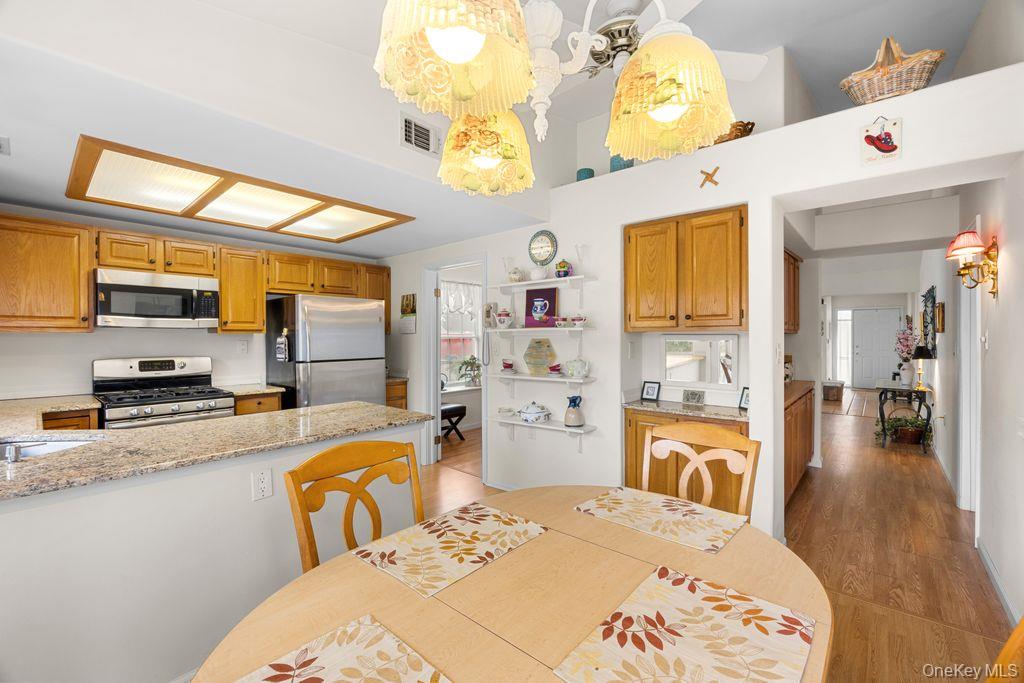 16 Huntington Court Ridge, NY 11961 - Photo 23 of 43 a kitchen with stainless steel appliances granite countertop a sink dishwasher stove and refrigerator with wooden floor