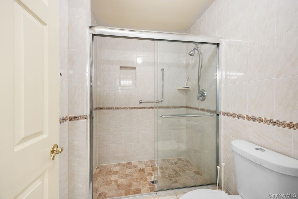 16 Huntington Court Ridge, NY 11961 - Photo 31 of 43 a bathroom with a glass shower door