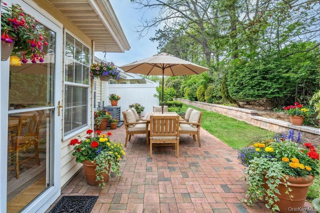 16 Huntington Court Ridge, NY 11961 - Photo 32 of 43 a view of a patio with a table and chairs under an umbrella