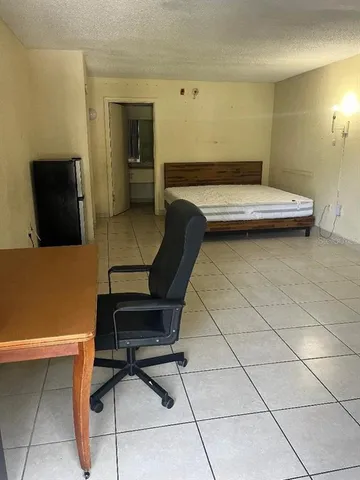 a bedroom with a bed and a potted plant