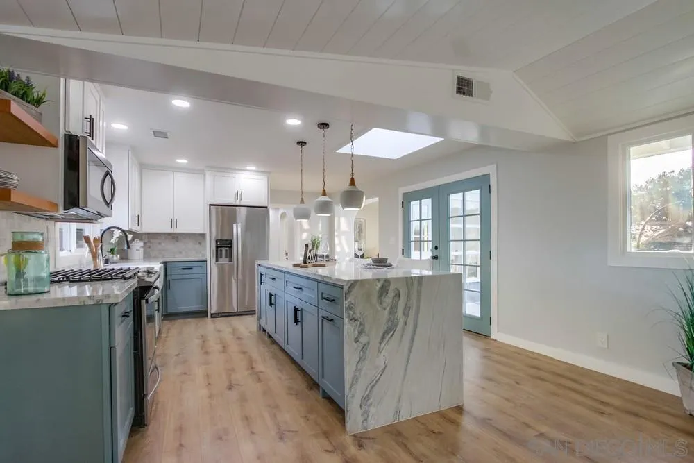 545 Ocean View Avenue Encinitas, CA 92024 - Photo 27 of 75 a kitchen with stainless steel appliances granite countertop a refrigerator a sink dishwasher a stove and a dining table with wooden floor