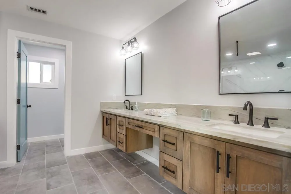 545 Ocean View Avenue Encinitas, CA 92024 - Photo 35 of 75 a bathroom with a double vanity sink a mirror and a