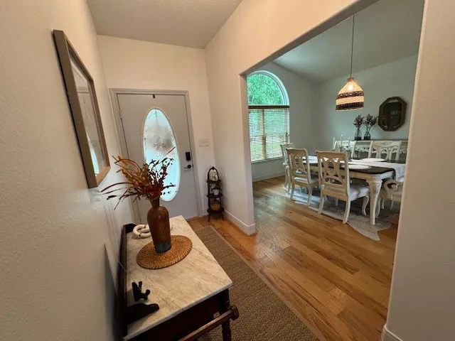 a living room with furniture a dining table with wooden floor and a large window