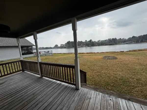 a view of a balcony with wooden floor next to a lake