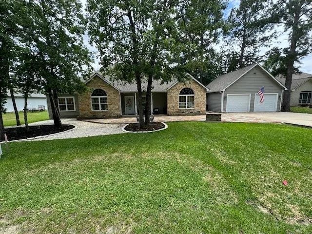 a front view of a house with a yard and trees