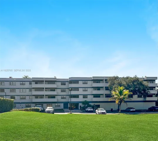 a view of building with garden and bench