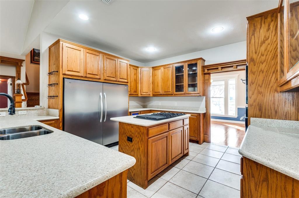 5520 Dido Hicks Road Fort Worth, TX 76179 - Photo 15 of 33 a kitchen with stainless steel appliances granite countertop a stove a refrigerator a sink dishwasher and wooden cabinets with wooden floor