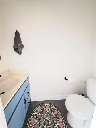 a bathroom with a granite countertop toilet and a sink