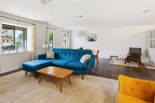 a living room with furniture wooden floor and a window
