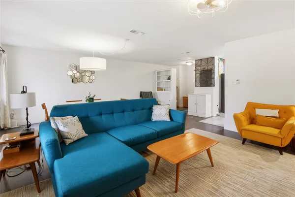 a living room with furniture and a wooden floor
