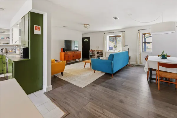 a living room with furniture and a wooden floor