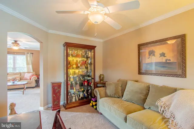 a living room with furniture a large window and a chandelier