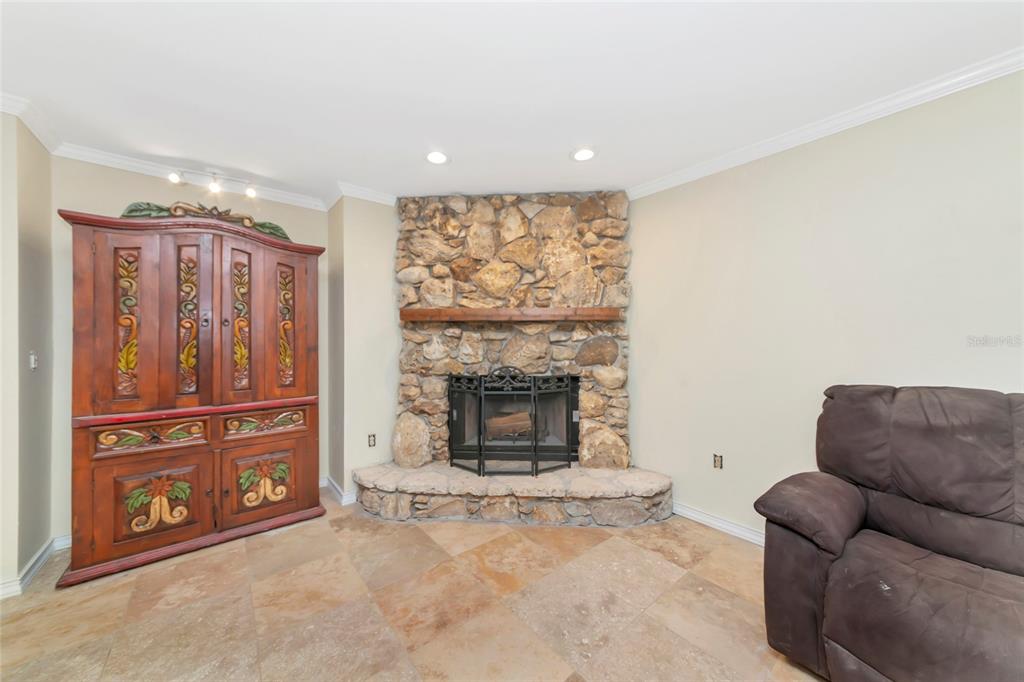 4656 Alexander Pope Lane Sarasota, FL 34241 - Photo 15 of 42 a living room with furniture a fireplace and a flat screen tv