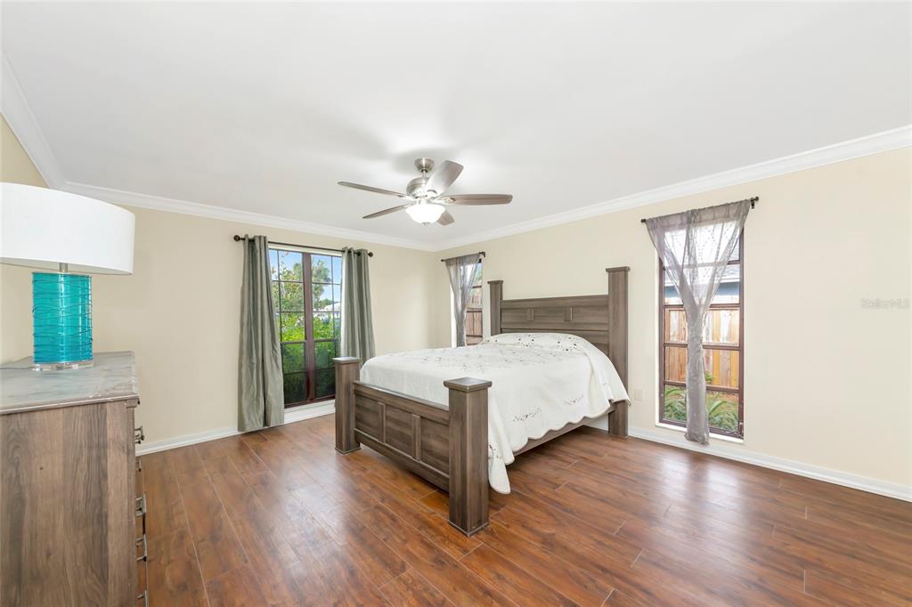 4656 Alexander Pope Lane Sarasota, FL 34241 - Photo 16 of 42 a bedroom with a large bed wooden floor and window