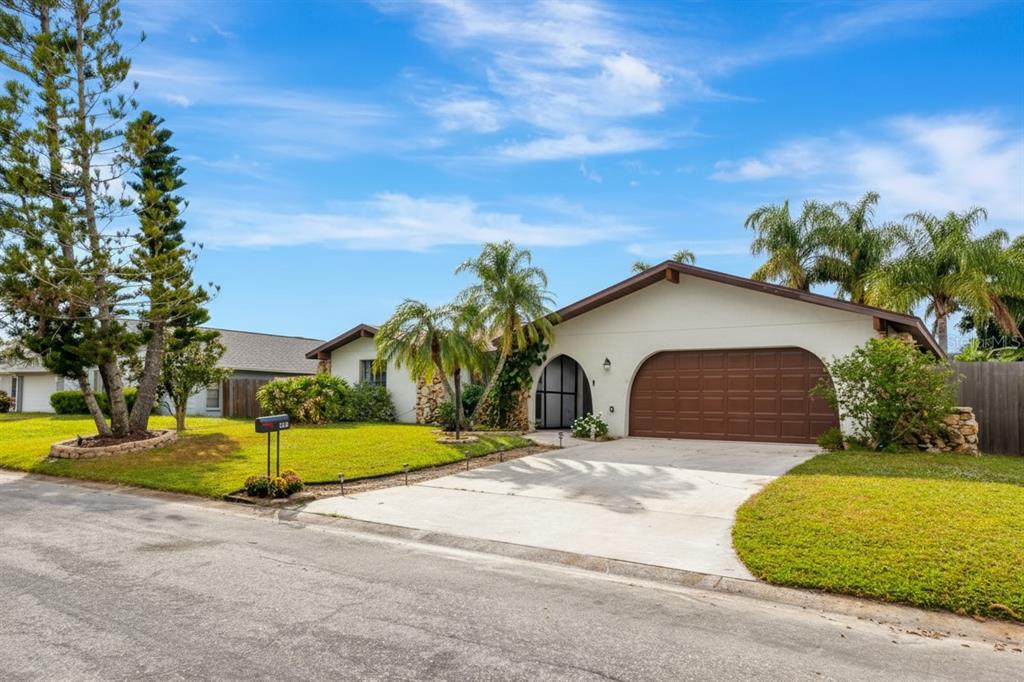 4656 Alexander Pope Lane Sarasota, FL 34241 - Photo 2 of 42 a front view of a house with a yard and garage