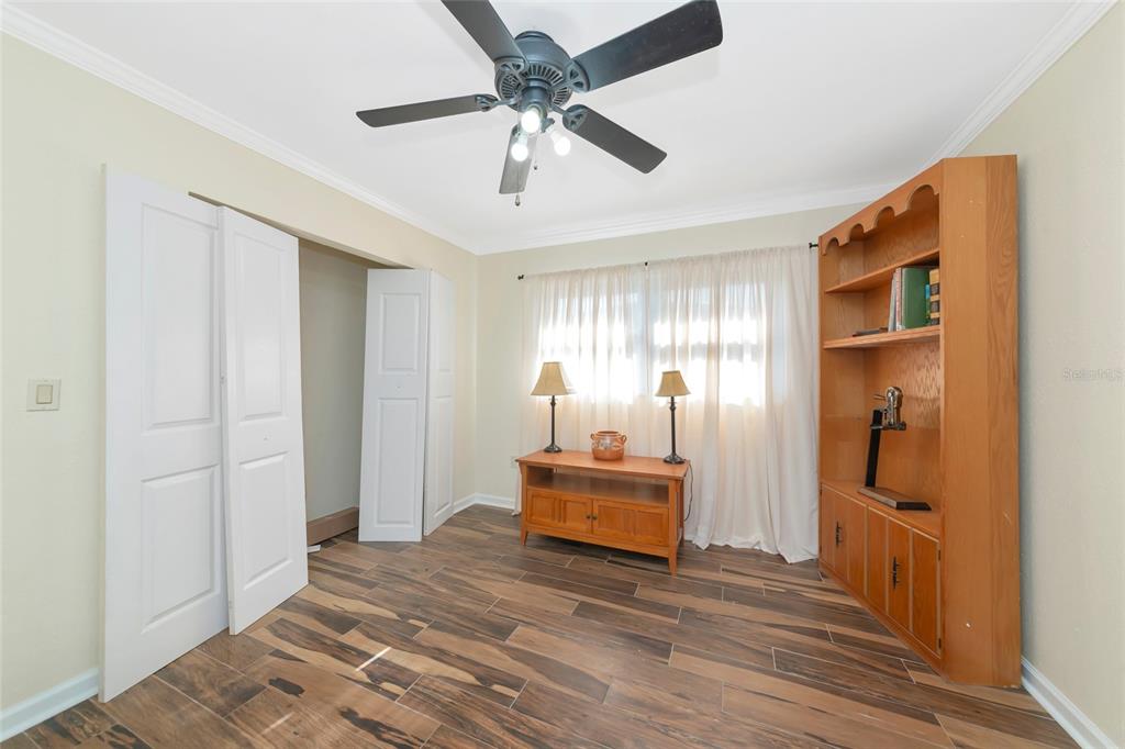 4656 Alexander Pope Lane Sarasota, FL 34241 - Photo 27 of 42 a view of a hallway to a bedroom with wooden floor and a ceiling fan
