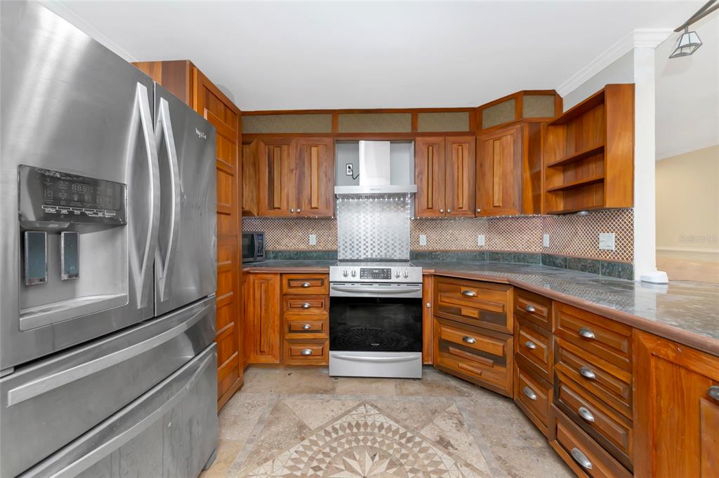 4656 Alexander Pope Lane Sarasota, FL 34241 - Photo 10 of 42 a kitchen with granite countertop a sink stainless steel appliances and cabinets