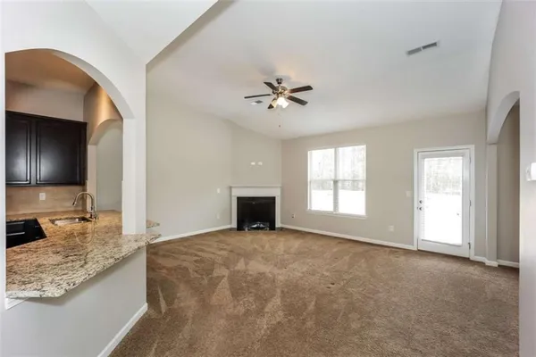 a view of an empty room with a fireplace and a window